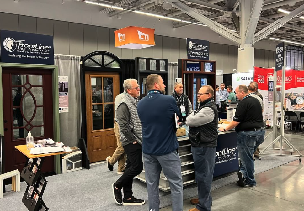 Supplier and dealer representatives talking beside a trade show booth
